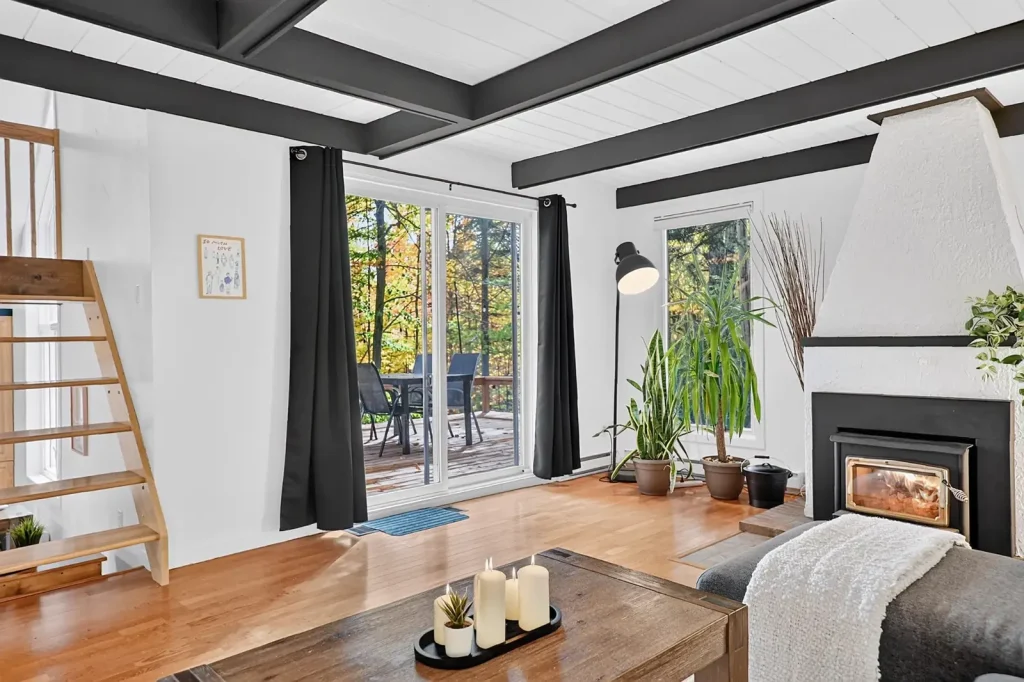 Salon sous poutres apparentes avec poêle à bois, au 9, rue des Épinettes à Orford