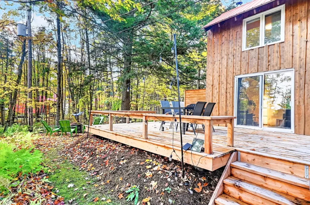Grande terrasse en bois au milieu du boisé, au 9, rue des Épinettes à Orford